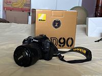 Nikon D90 camera body with box in background and strap attached