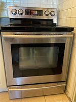 Front view of Samsung stainless steel range showing oven door, control panel and warming drawer