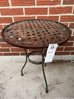 Full view of the vintage metal lattice end table showing round top, three curved legs, and circular leg support.