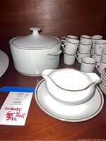 Covered casserole dish, stacked cups, gravy boat on plate showing gold trim and handles