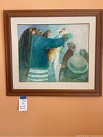 Full view of painting showing abstract human figures in teal and blue tones, in light wood frame.
