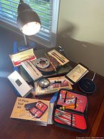 Wide view of desk items including desk lamp, Cross pens, magnifier, letter opener, and tool kit.