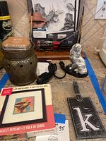 Photo of Scentsy warmer with baked apple pie wax, silver rabbit figurine, punch needle set, black luggage tag with letter 'k', and power cords on kitchen counter.
