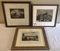 Photo of three framed engravings/etchings arranged on a surface showing overall condition and framing.