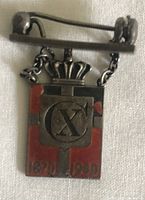 Front view of lapel badge showing red enamel, crown and dates 1870-1940