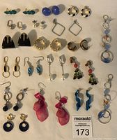 Photo shows an assortment of 18 pairs of vintage costume earrings of various styles, materials and colors.