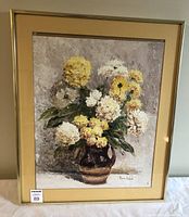 Full view of the framed oil painting showing yellow and white flowers in a brown vase with a neutral background.