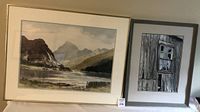 Pair of framed watercolour paintings side by side, one landscape lake scene, one barn window close-up.