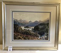 Framed watercolour landscape painting with silver frame and cream mat with blue trim.