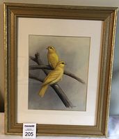 Full view of the framed watercolour painting showing two yellow canaries on tree branches in a gold wooden frame with white matting.