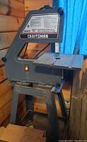 Full view of Craftsman band saw showing base, frame, work table and motor housing with Craftsman logo