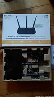 D-Link AC750 Wireless Dual Band Router in original box with antennas and power adapters shown in packaging