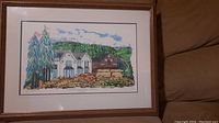 Framed print of Rouge Valley landscape showing house and trees under glass in wooden frame.