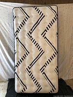 Twin-size mattress with black and white geometric pillowtop design.