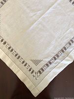 Close-up of corner and edge of large 29-inch Irish linen piece showing solid center and triangular corner cutwork detail