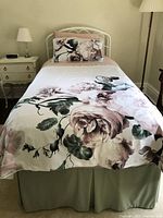 Full view of twin bed set up with floral duvet cover and matching pillow sham featuring dusty pink roses and green leaves, polyester microgel duvet underneath.