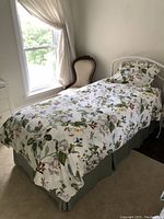 Twin bed made with one of the floral and insect patterned twin duvet covers and matching pillow sham, showing full bedding setup on a twin bed.