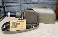 Photo of Aldis Star projector with lens and instruction manual, showing projector on surface alongside the manual and cables.