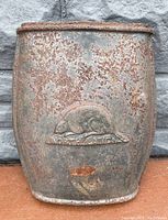 Full view of the cast iron woodstove door showing overall rusted condition and beaver logo.