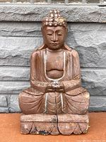 Front view of the antique wooden Buddha statue showing carved details, cracks and overall condition.