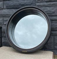 Front view of large circular mirror with antique wooden frame and visible "3 1/2" mark, showing reflective glass surface.