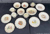 Full view of the Royal Doulton Bunnykins porcelain china set with multiple plates and cups, showing the colorful Bunnykins illustrations and patterned borders.