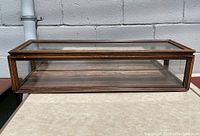 Front view showing clear glass front panel and wood frame