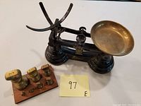 Photo showing the scales with the set of brass weights on wooden rack and seller's lot number note 97.