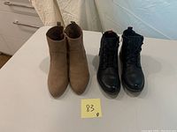 Front view of both pairs of boots: beige Old Navy on left, black Wanderless on right.