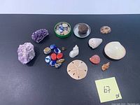 Full assortment showing amethyst, purple quartz, polished stones, various seashells including sand dollar and conch shell.
