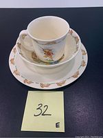Set of Peter Rabbit Bunnykins children's china items including cup, bowl, and plate stacked together showing character illustrations.