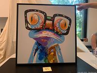 Front view of the colorful frog painting with large glasses, showing the inset black frame.