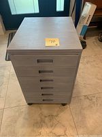 Front view of the closed cabinet showing all six drawers and casters below.