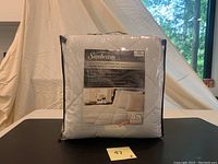 Packaged Sunbeam Twin Size Quilted Heated Mattress Pad in plastic carrying case with label visible