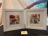 Two framed flower art prints side by side showing colorful floral designs in white square frames.