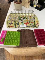 Cooling rack, decorative tray, and four silicone moulds on countertop.
