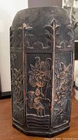 Closed panel view showing detailed floral carving on the wood surface.