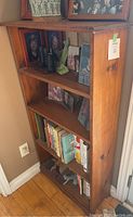 Side view of wooden bookshelf with some books and decorative items on shelves (not included in sale)