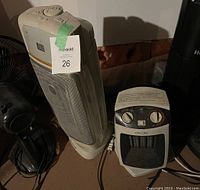 Photo showing two electric heaters: a tall vertical heater on the left and a smaller cube-shaped heater on the right, both untested