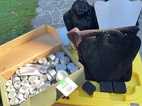 Box with many small round aluminum bead containers along with black velvet jewelry display busts and small black pads.