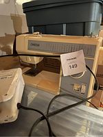 Photo of vintage beige Omega sewing machine showing brand name, stitch selection guide, power switches, and power cord.