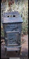 Front view of wood stove showing cast iron door with ventilation control and top hole missing disc insert.