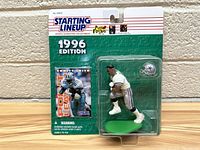 Front view of 1996 Starting Lineup Emmitt Smith action figure in original packaging against brick background.