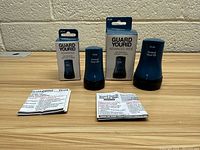 Photo showing two blue Guard Your ID stamps with their original boxes and instruction leaflets.