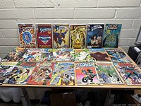 Overview of 20 vintage comic books laid out on a table showing front covers including Superman, Flash Gordon, Conan, Fantastic Four and others