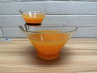 Side view of orange glass chip and dip set on metal holder showing color and shape.