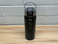 Front and back view of the black Surelos vacuum insulated water bottle featuring key product information printed in white.