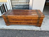 Front view of wooden storage trunk chest showing natural wood finish and metal corner brackets