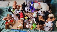 Collection of various Beanie Babies and plush toys arranged on a surface featuring multiple animals.