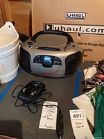 Photo of the boom box and Whistler radar detector together on a table.